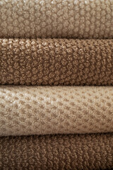 Stack of towels in neutral colors texture as a background. Fabric bathroom accessories for hygiene, spa and skin care.