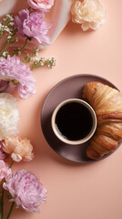 Cup of black coffee and croissant on a plate on pastel pink background with spring flowers.