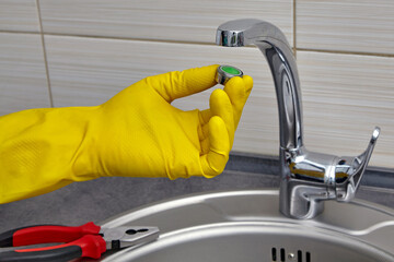 replacing the mixer aerator in a metal sink. work on house