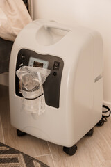 Medical Oxygen Concentrator Machine with Mask on Wooden Floor, Home Healthcare Concept, White...