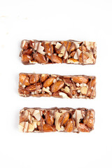 three caramel nut bars isolated on a white background. top view with copy space.