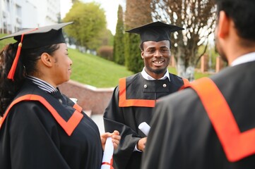 Diverse international students with diplomas attending graduation ceremony, happy multiracial group...