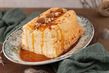 A slightly angled close-up features a traditional caramelized egg white pudding known as molotof or molotov, generously drizzled with rich caramel and adorned with whole and chopped almonds