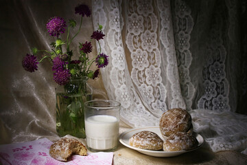 Still life with a glass of milk and fresh glazed gingerbread.