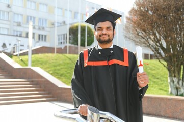 Portrait of happy man, graduation or student in university campus
