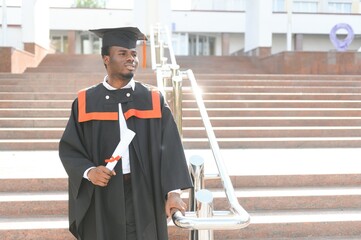 smiling african american graduated student showing diploma