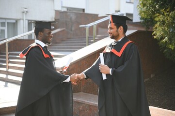 Two friends are university graduates. Indian and African graduates