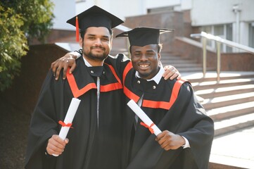 Happy boys students university graduates. Multiracial students