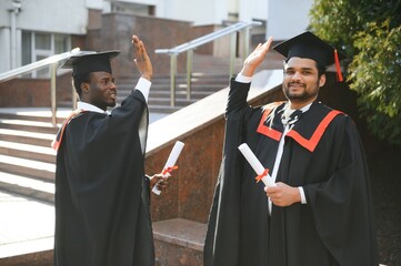 Happy boys students university graduates. Multiracial students