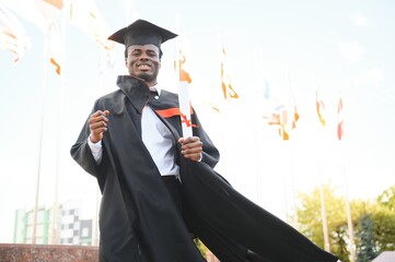 smiling african american graduated student showing diploma