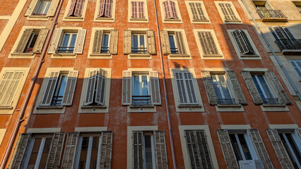 Colorful facade with traditional shutters in afternoon light, Rue des Vertus, Marseille, France. Classic Mediterranean architecture, vibrant textures and authentic city atmosphere.