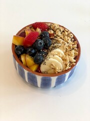 Smoothie Bowl with Fresh Fruit, Granola, and Chia Seeds on White Background