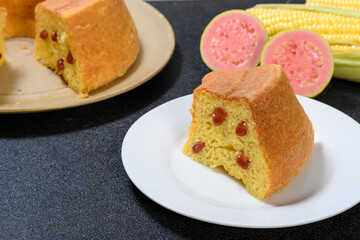  slice of corn cake with guava on a white prata, corn cob and guava fruit