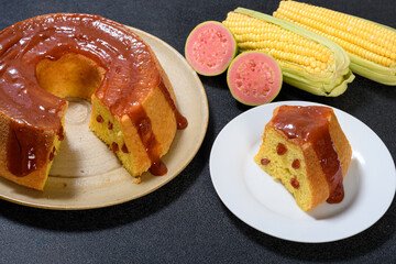  slice of corn cake with guava on a white prata, corn cob and guava fruit