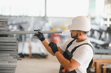 Portrait of cheerful young worker wearing hardhat at modern factory