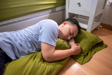 Indonesian southeast asian husband sleeping separately from his wife in the bedroom. Having a...
