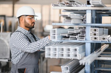 Portrait of cheerful young worker wearing hardhat at modern factory