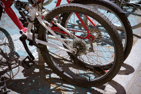 Parked bicycles showing rear wheels and bicycle chain - Powered by Adobe