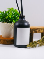 reed diffuser bottle with blank label and rustic decoration studio scene background