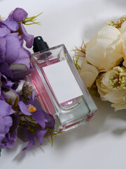 Perfume bottle mockup with plain white label, flowers background decoration, studio scene