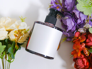 soap bottle with plain white label on bouquet of flowers scene