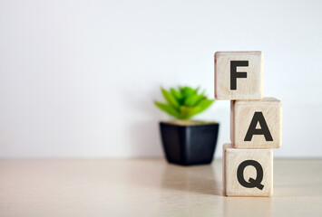 FAQ - concept on wooden cubes, on wooden flowers background