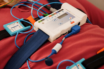 Stationary Polysomnography System Setup on Red Bed During Sleep Study Monitoring with ECG Cables, Device Interface, Medical Sensors