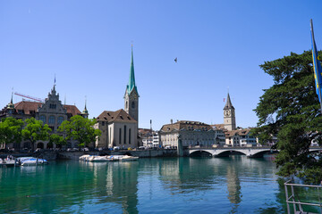 Fototapeta premium Scenic view of skyline of the medieval old town of Swiss city of Zürich with church tower and Limmat River on a sunny summer afternoon. Photo taken June 25th, 2025, Zurich, Switzerland.