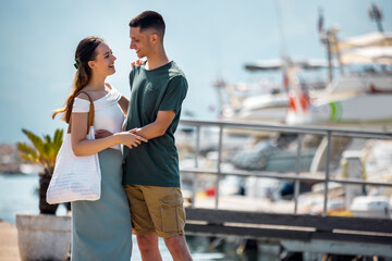 Fototapeta premium Couple Embracing and Looking at Each Other by Yachts on the Sea