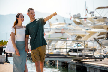 Fototapeta premium Couple Holding Hands Walking Around Yacht Deck, Amazed by Luxury Boats