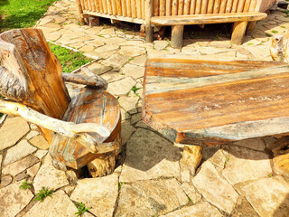 Rustic wooden chair and table set on stone patio in natural outdoor setting