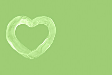 Heart shape made of white cream on pastel green background. Perfect for natural cosmetics,...