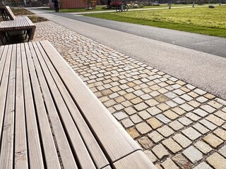Modern gardening and patio design: a mix of paving stones, paved path, wooden benches, and...