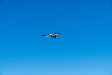 Flying drone against blue sky