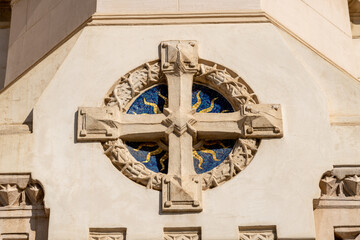 Stone cross with blue mosaic in cathedral wall