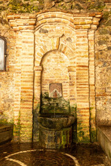 Old stone fountain with arched brickwork