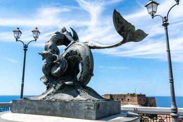 Mermaid statue on terrace with fortress and sea