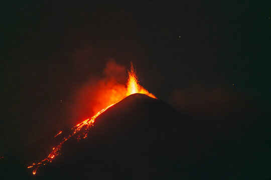 Lava fountain and glowing flows at night