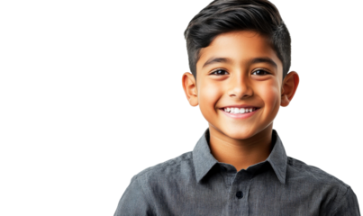 Happy young boy with a bright smile wearing a gray shirt against a dark background representing joy and innocence in childhood portrait photography