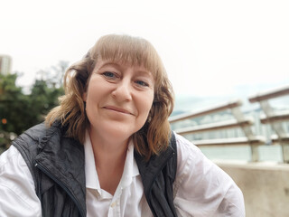 Mature blonde woman enjoying a casual selfie during her travel adventure in Hong Kong