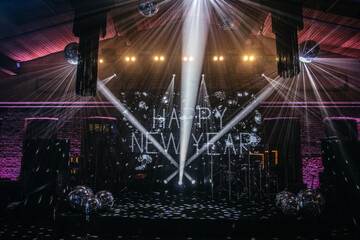 A festive New Year celebration setup with a stage beautifully illuminated by dynamic lighting and...
