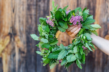 Hand Holding Green and Purple Herb Wreath
