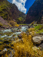 Serene river flowing through rocky canyon in mountainous Kyrgyzstan region