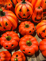 Halloween pumpkins showing scary faces resting on wooden table