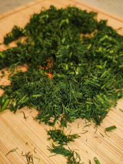 Freshly chopped dill on wooden cutting board
