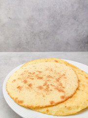 Delicious homemade flatbreads resting on a white plate, copy space
