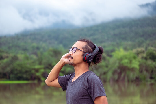 Man enjoying music in nature with serene view.