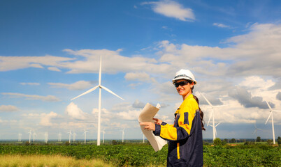 Smiling female engineer wind turbine : Female architect planning wind energy project in wind farm...