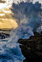 Temporal en el mar Menorca olas salpicando sobre las rocas al atardecer