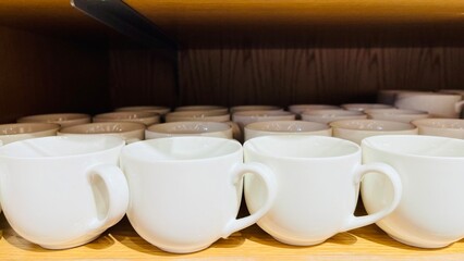 A set of white cups for tea or coffee on wooden background close up